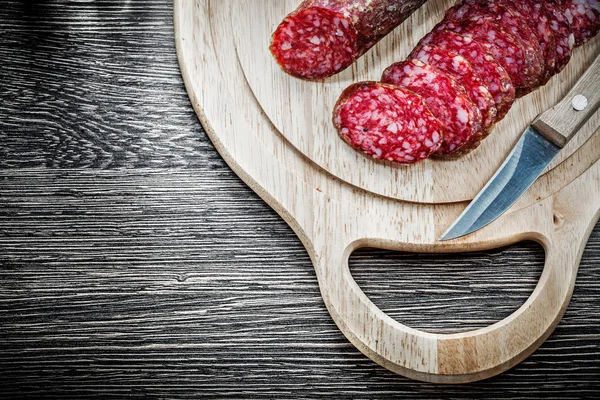 Cuchillo salami picado en tabla de tallar de madera — Foto de Stock