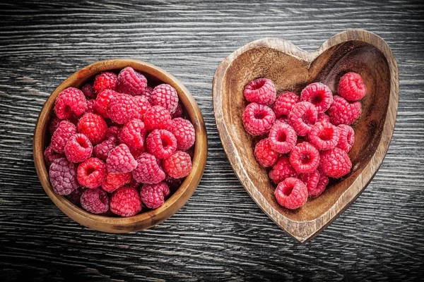 Yuvarlak ve kalp şeklindeki kase ile Ahududu ahşap tahta üzerinde