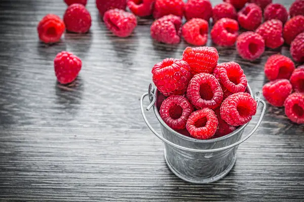 Ripe raspberries in basket on wooden board — Stock Photo, Image