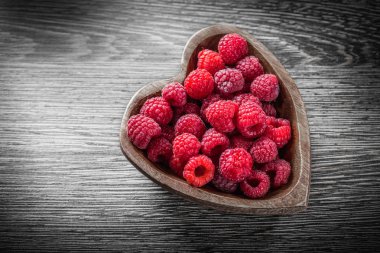 Kalp şeklinde kase Kırmızı Ahududu ahşap tahta üzerinde