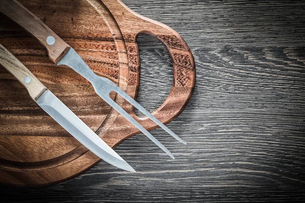Vlees vork mes snijwerk bestuur op houten achtergrond — Stockfoto