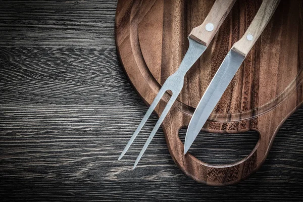 Forquilha de carne faca tábua de corte no fundo de madeira — Fotografia de Stock