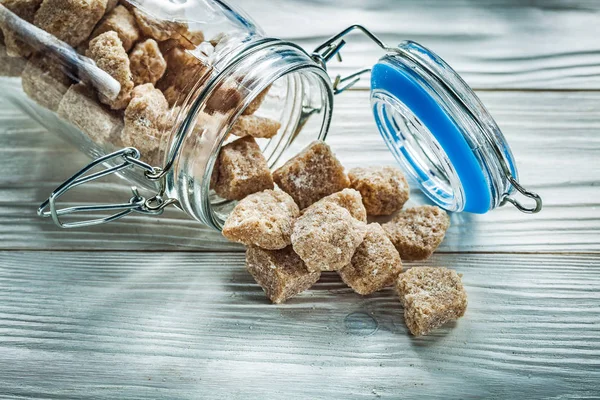 Brown sugar cubes jar on wooden board — Stock Photo, Image