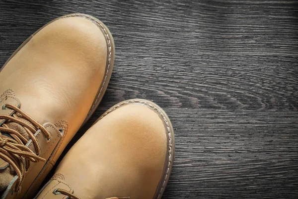 Par de botas de seguridad impermeables en tablero de madera vintage —  Fotos de Stock