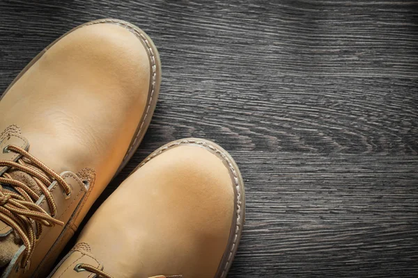 Pair of waterproof safety boots on vintage wooden board — Stock Photo, Image