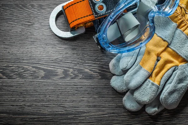 Set of protective gloves belt glasses on wooden board — Stock Photo, Image