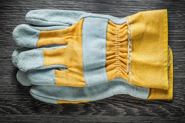 Protective gloves on wooden board top view — Stock Photo, Image