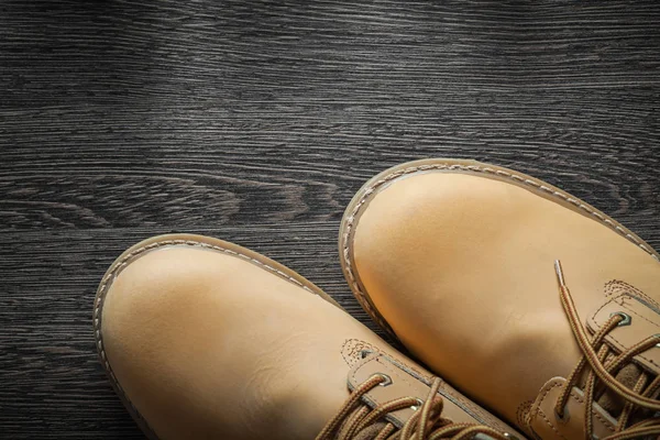 Par de botas de trabajo impermeables en tablero de madera vintage — Foto de Stock