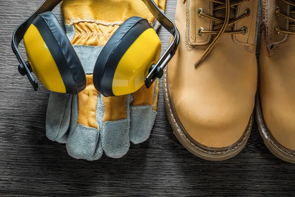 Protective gloves working lace boots ear muffs on wooden board — Stock Photo, Image