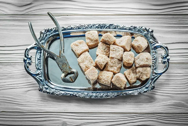 Bandeja de alicates de azúcar marrón sobre tabla de madera —  Fotos de Stock