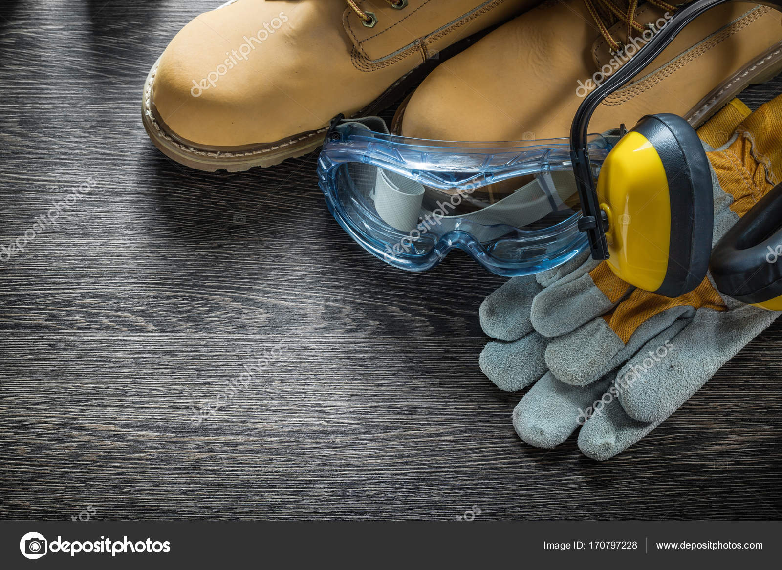 Safety gloves boots goggles earmuffs on wooden board — Stock Photo
