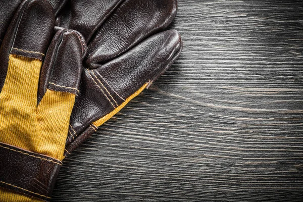 Brunt läderhandskar på träskiva — Stockfoto