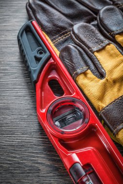 Ahşap tahta üzerinde inşaat seviyesi koruyucu eldivenler