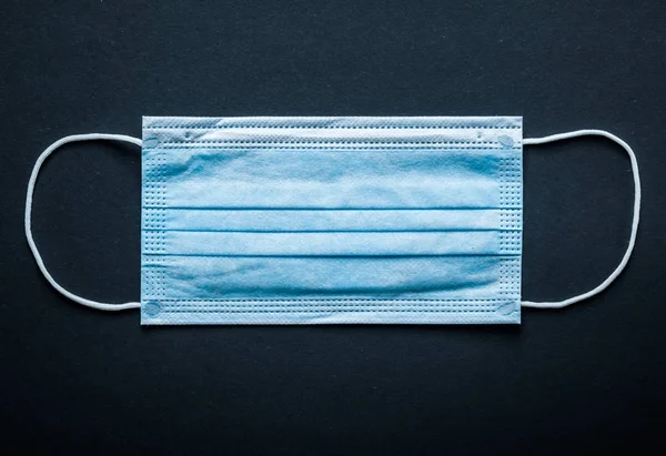 Disposable sterile surgical mask on black background