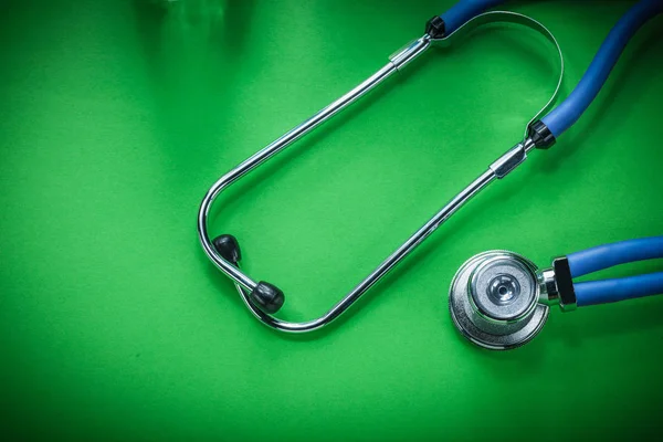Medical auscultator on green background — Stock Photo, Image