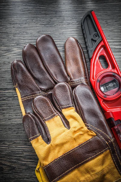 Conjunto de guantes de seguridad de nivel de construcción en tablero de madera —  Fotos de Stock