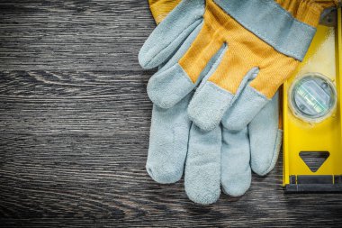Sarı inşaat seviyesi Emanet eldiven ahşap tahta üzerinde