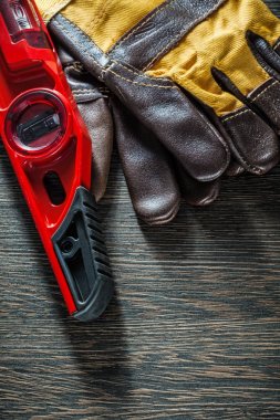 Ahşap tahta üzerinde inşaat seviyesi koruyucu eldivenler