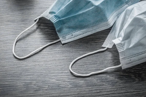 Sterile face masks on vintage wooden board top view — Stock Photo, Image