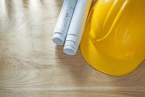 Building helmet blueprints on wooden board — Stock Photo, Image