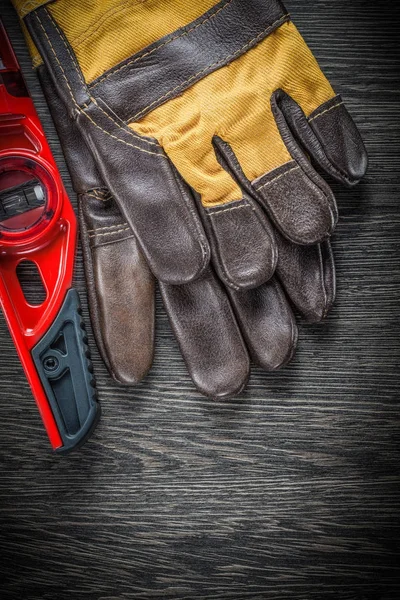 Guantes de seguridad de cuero a nivel de construcción en tablero de madera —  Fotos de Stock