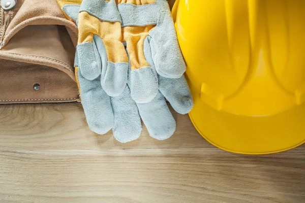 Hard hat safety gloves leather tool belt on wooden board — Stock Photo, Image