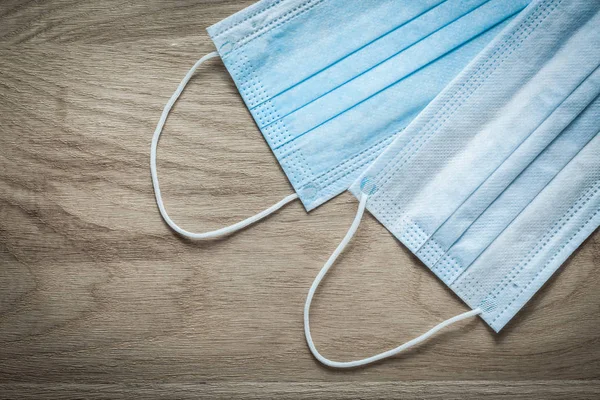 Disposable surgical face masks on wooden board