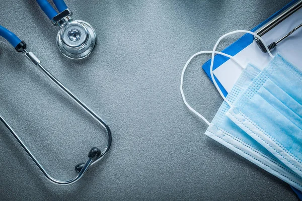 Stethoscoop clip board wegwerp gezichtsmasker op grijze achtergrond — Stockfoto