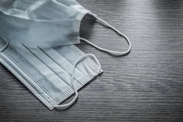 Máscaras médicas protectoras blancas en tablero de madera vintage — Foto de Stock