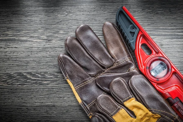 Set of construction level protective gloves on wooden board — Stock Photo, Image