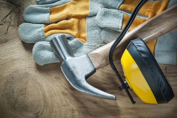 Claw hammer beschermende handschoenen oorkappen op houten bord — Stockfoto