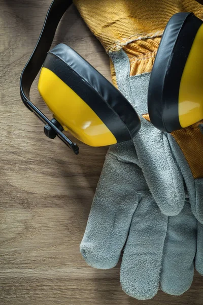 Paraorecchie paio di guanti di sicurezza su tavola di legno — Foto Stock