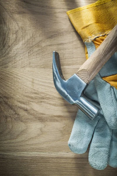 Claw hammer pair of safety gloves on wooden board — Stock Photo, Image