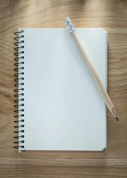Spiral notepad pencil on wooden board — Stock Photo, Image