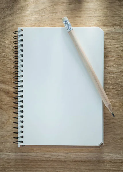 Spiral notepad pencil on wooden board — Stock Photo, Image