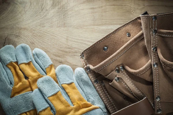 Kožený pás ochranné rukavice v návaznosti na dřevěné desce — Stock fotografie