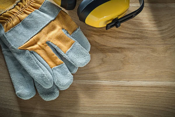 Casques d'oreilles gants de sécurité sur panneau de bois — Photo