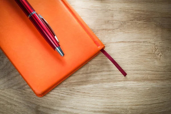 Orange anteckningsbok kulspetspenna ovanifrån — Stockfoto