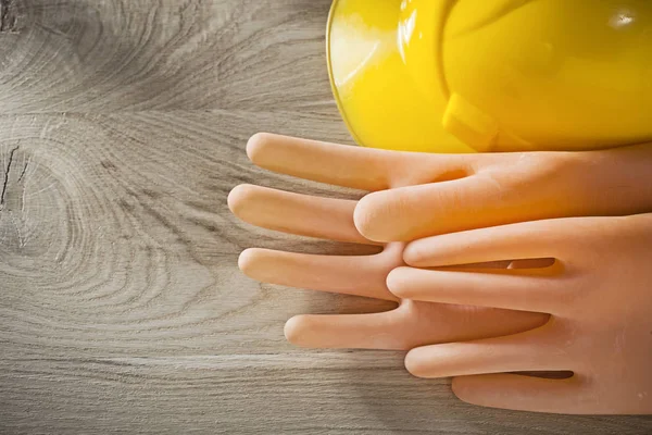 Electricians gloves building helmet on wooden board