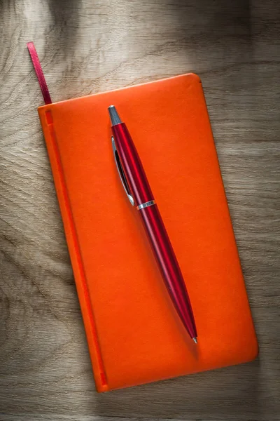 Notebook laranja biro caneta vista superior — Fotografia de Stock