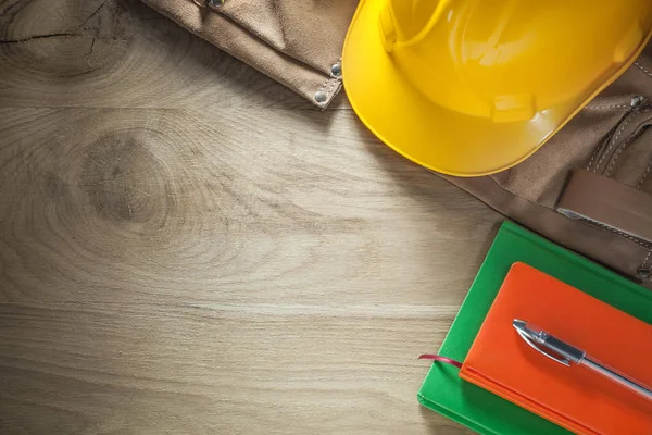 Notizbücher Stift Leder Werkzeug Gürtel Bau Helm auf Holzbrett — Stockfoto