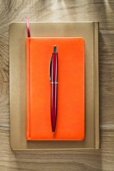 Blocchi appunti chiusi penna su tavola di legno — Foto Stock
