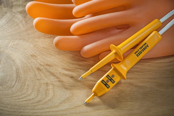 Electric tester dielectric gloves on wooden board