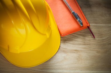 Kask defter kalem ahşap tahta üzerinde bina vintage