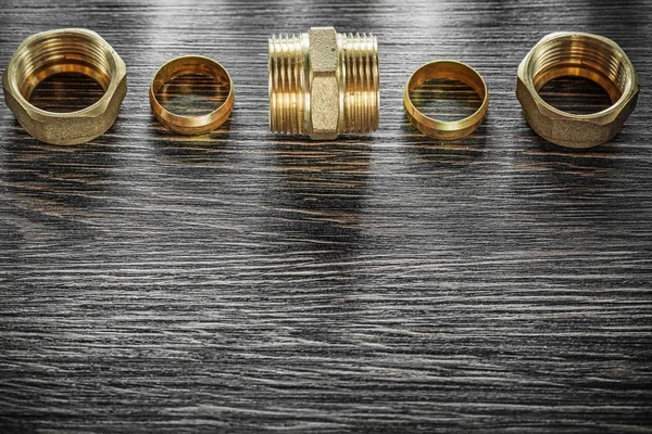 Threaded pipe fittings on vintage wooden board — Stock Photo, Image