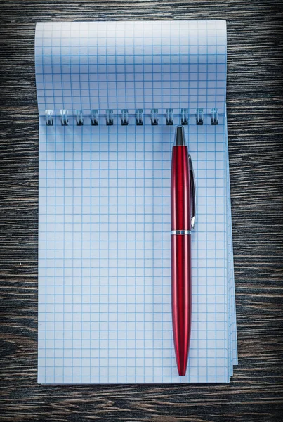 Checked notebook ballpoint pen on vintage wooden board — Stock Photo, Image