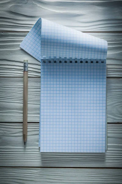 Lápis de bloco de notas verificado na placa de madeira branca — Fotografia de Stock