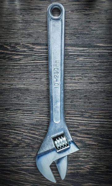 Adjustable spanner on wooden board — Stock Photo, Image