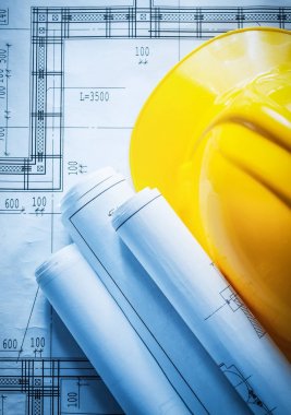 Planı üzerinde inşaat çizimleri haddelenmiş bina kask