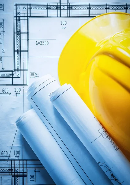 Planı üzerinde inşaat çizimleri haddelenmiş bina kask